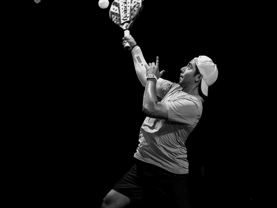 Padel player reaching for an overhead